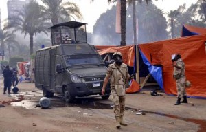  Egyptian security forces move in to clear one of the two sit-in sites of supporters of ousted president Morsi, at Nahda square, near Cairo University, Cairo, Egypt, 14 August 2013. According to local media reports, one soldier and dozens of protesters were killed and about 200 others arrested as Egyptian security forces began clearing islamist protest camps in the capital Cairo on 14 August. The military-backed government described the protest camps as violent and unlawful. The biggest sit-ins are in north-eastern Cairo and south of the capital.  EPA/GINA MOHAMED