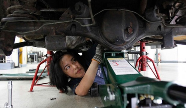 Vina Jane Aranas, 17, lay on the floor while learning how to align the wheels of a car as part of her automotive training at the Technical Educational Skills and Development Authority (TESDA) in Taguig city, metro Manila